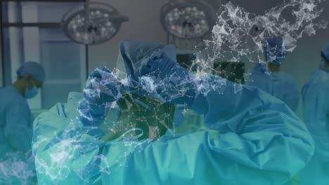 surgical team adjusting headlamp observing monitors in operating room with data network overlay