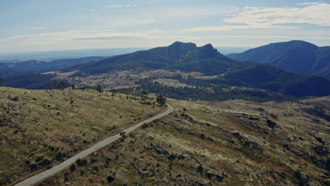 antena siguiendo el coche por el remoto camino de tierra de la montaña durante el día, 4k