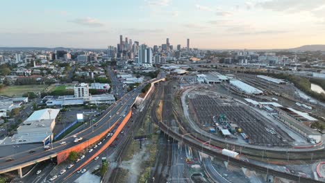 establishing pull away drone shot of brisbane city, pan up shot during sunset, flying over the inner city bypass icb road network