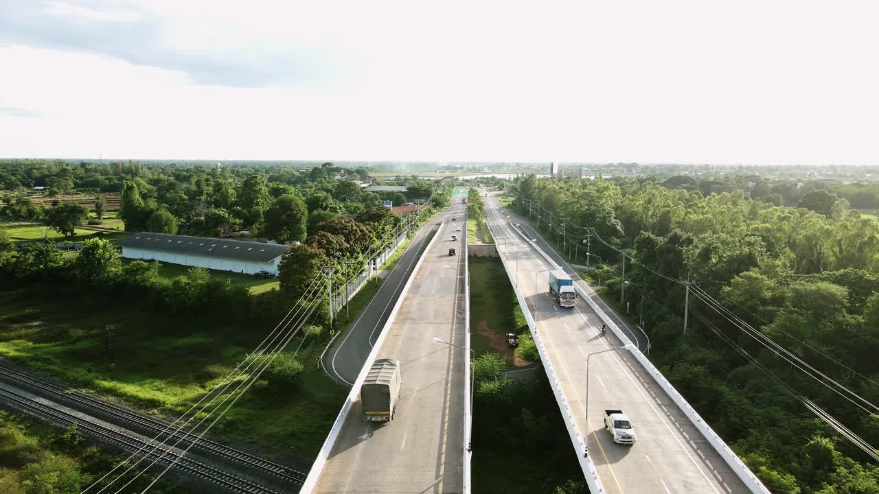 태국 콘카엔(khonkaen)의 도로에서 교통량이 많은 철도 건널목 다리와 나무 숲의 공중 야생 전망