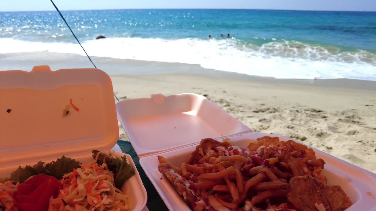 Tilt opp av stekt fisk og salat på Tinikijima-stranden, Aragua, Venezuela.