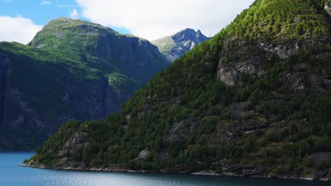 Riesige-Geiranger-Fjordlandschaft,-Von-Einem-Kreuzfahrtschiff-Aus-Gesehen,-Große-Berge,-Die-In-4k-Aus-Dem-Blauen-Wasser-Ragen