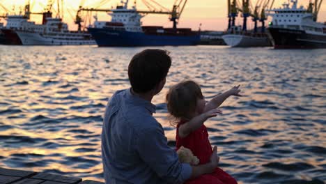 father and daughter at sunset harbor