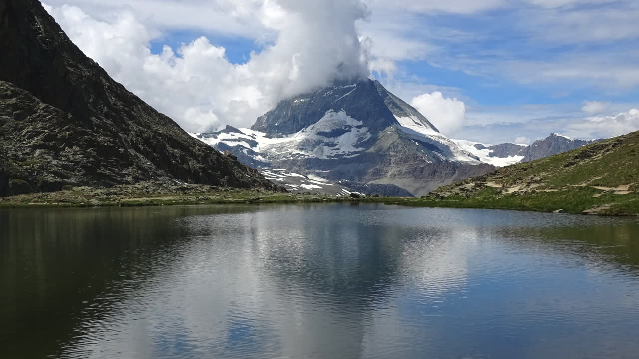 Filmato in timelapse del Cervino riflesso nel tranquillo lago Stellisee, con nuvole in movimento e paesaggio alpino vicino a Zermatt, Vallese, Svizzera, alla luce del giorno estiva.