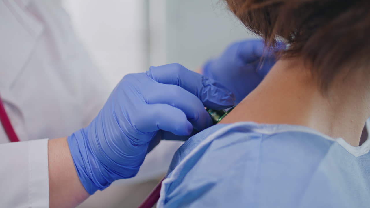 Doctor hands holding stethoscope listening patient in healthcare clinic closeup