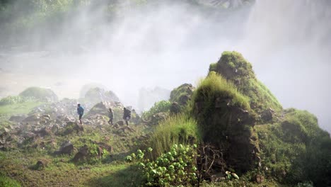 three men walk near blue nile waterfalls