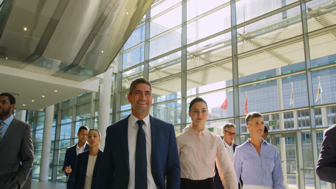 personas de negocios multiétnicas caminando juntas en el vestíbulo de la oficina 4k