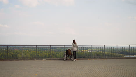 redhead woman and little girl in wheelchair enjoy nature