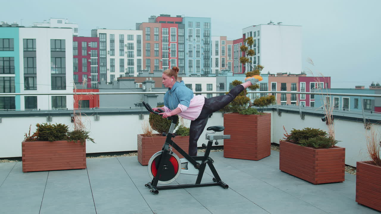 여성은 시 ⁇ 레이터, 사이클 트레이닝에서 유산소 지구력 훈련 운동 심장 루틴을 수행합니다.