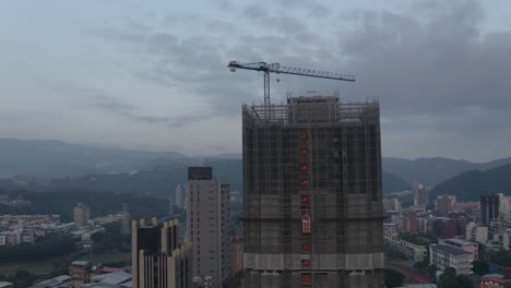 Eine-Drohnenaufnahme-Eines-Im-Bau-Befindlichen-Gebäudes-In-Taipeh-In-Der-Abenddämmerung,-Wo-Man-Einen-Aufzug-Sehen-Kann,-Der-Nach-Oben-Fährt