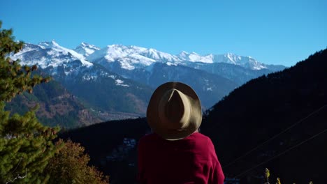 Hiker-Woman-Viewing-The-Scenic-Snowy-Mountain-Landscape-With-Blue-Sky-In-Manali,-India---Wide-Shot