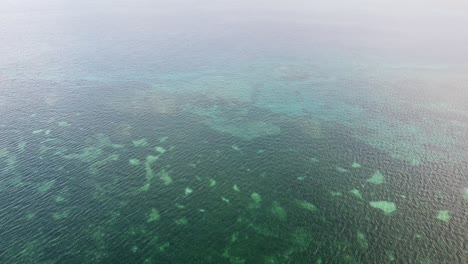 Vuelo-Aéreo-Sobre-Un-Hermoso-Arrecife-De-Coral-Con-Un-Océano-Turquesa-Ondulado-En-El-Diverso-Ecosistema-Triángulo-Coralino-De-Timor-Leste,-Sudeste-De-Asia