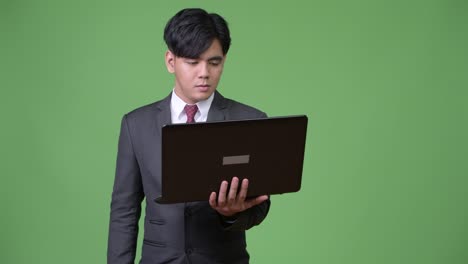 젊은 잘생긴 아시아 사업가 노트북을 사용