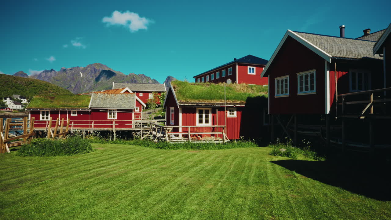 Panoramic view of the red wooden fishermen cabins in the Lofoten islands, Norway. View of the picturesque landscape in the background