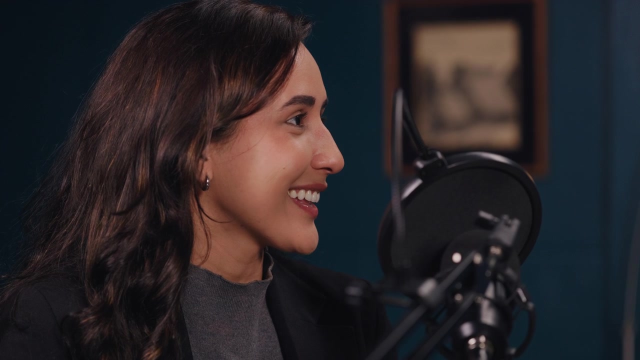 Giovane donna che parla al microfono in un ambiente di studio professionale