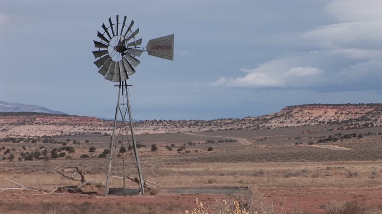 plano medio de un viejo molino de viento parado en una llanura desértica