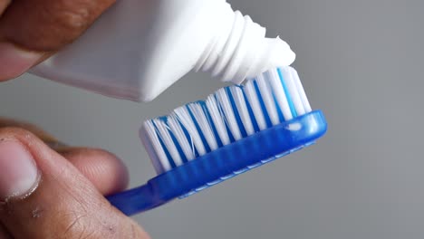 putting toothpaste on a toothbrush