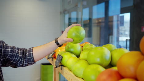 persona que compra pomelos en una tienda de comestibles