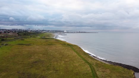 aerial drone shot flying over the cliffs of the north-east english coast, look over the city of sunderland on a cloudy day