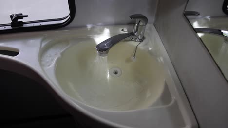 opening a water tap inside an old rv camper vans toilet