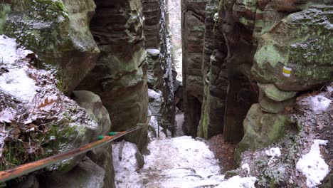 snowy-steps-between-a-sandstone-rock-formation-in-Prachov-Rocks,-Bohemian-Paradise,-dolly-in