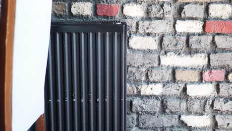 radiador negro contra una pared de ladrillo