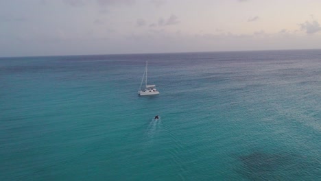 Aerial-Drone-View-of-Bahamas-secluded-island-with-solitary-sailboat-and-dingy