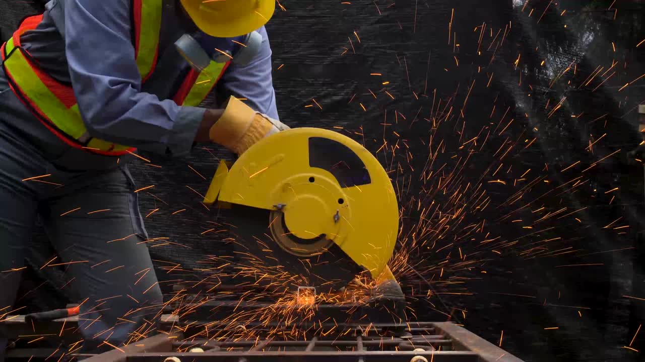 trabajador industrial en tela protectora azul usar máscara de seguridad, soldador profesional cortar estructura de acero con la emisión de chispas naranjas brillantes en la fábrica.
