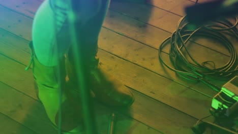 cantante femenina tocando los pies con luces intermitentes en una actuación en vivo