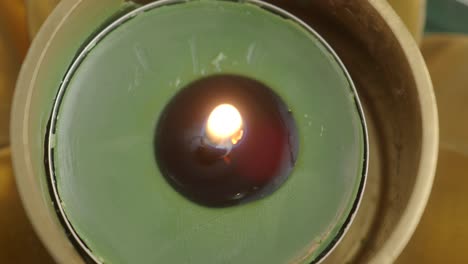 burning teal candle in holder