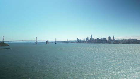 Zoom-out-Aerial-shot-of-the-Bay-Bridge-and-downtown-San-Francisco