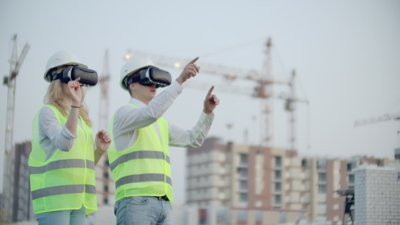 dos personas hombre y mujer con gafas de realidad virtual en el fondo de los edificios en construcción con grúas. gerente y asistente en el diseño con las manos imitando la interfaz de la aplicación