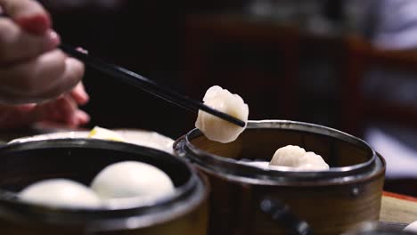 chopsticks picking shrimp dumplings from steamer