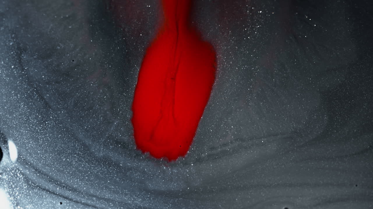 Fluid ink swirling and blending, creating a contrast of dark and vibrant colors, macro shot