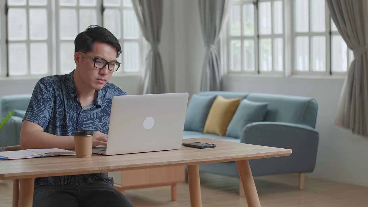 Stressed Man Working On Laptop Computer At Home, Video In 4K