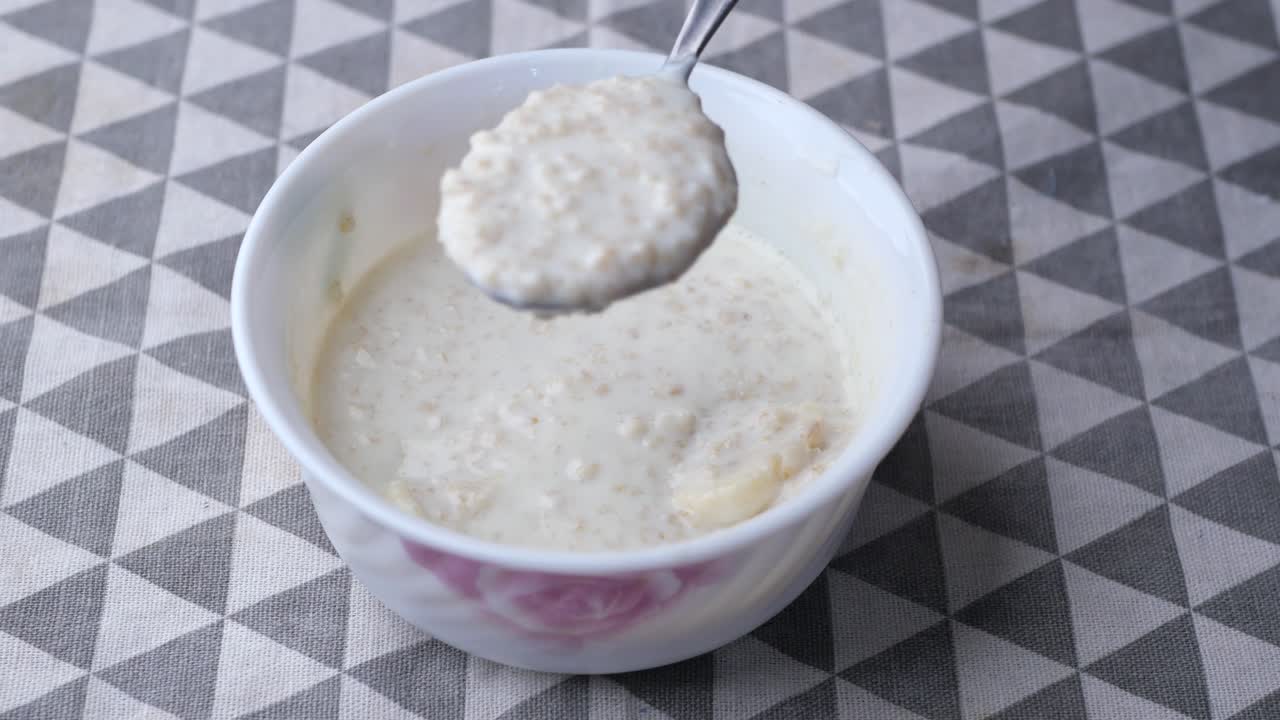 avena, plátano y leche en un tazón con fondo negro
