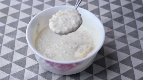 Oats,-banana-and-milk-in-a-bowl-on-black-background