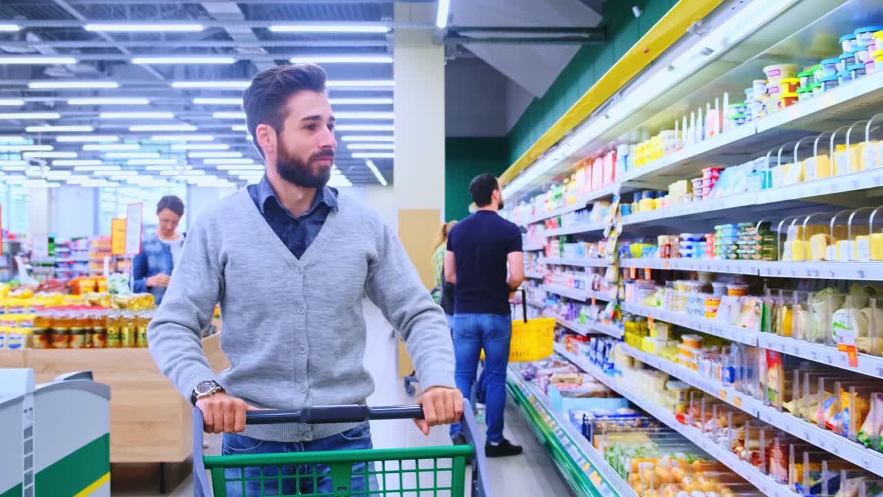 A Man Shopping at a Supermarket, Selecting Items for His Cart, Surrounded by Colorful and Diverse Grocery Products Displayed on Shelves