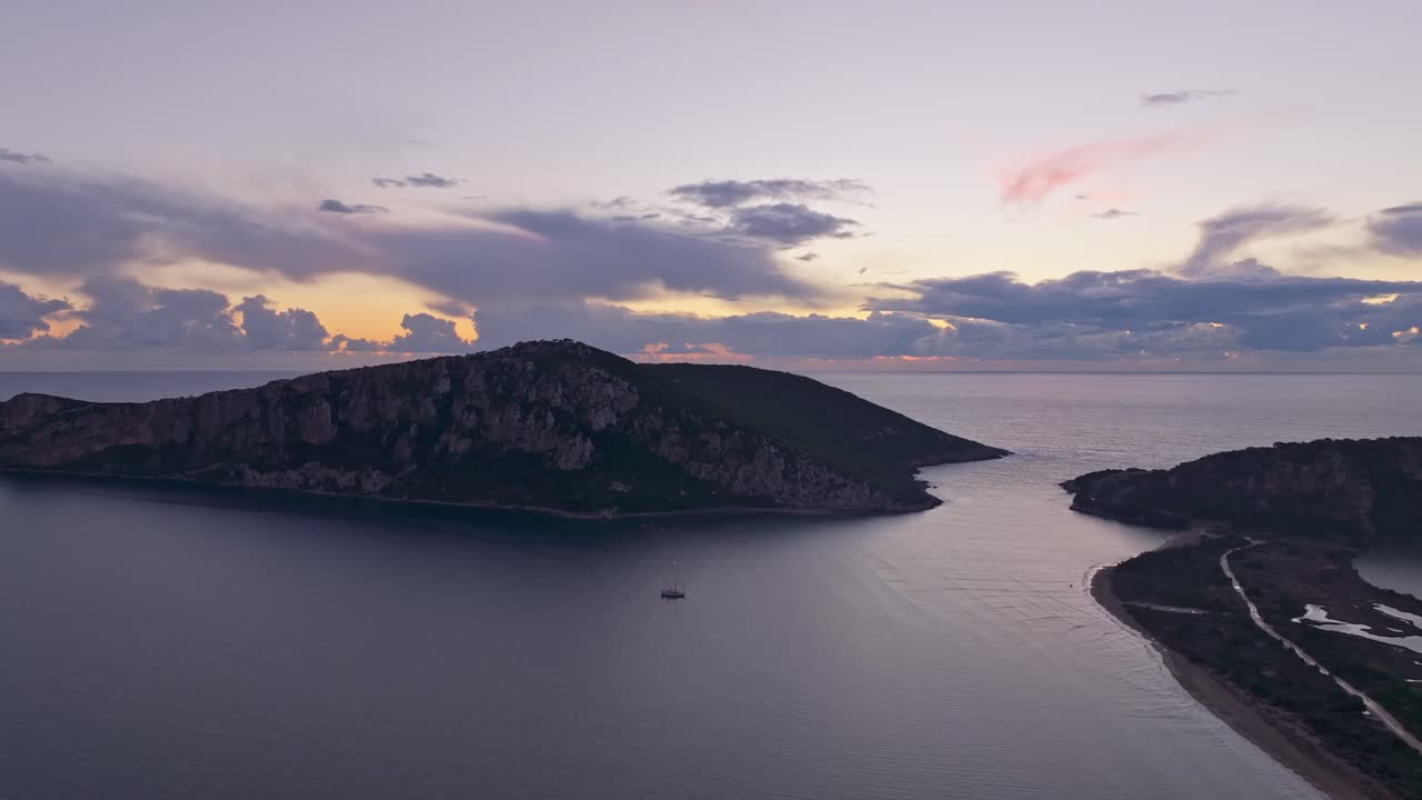 Dronebillede af yacht, der flyder på gyldne middelhavsvande ved solnedgang.
