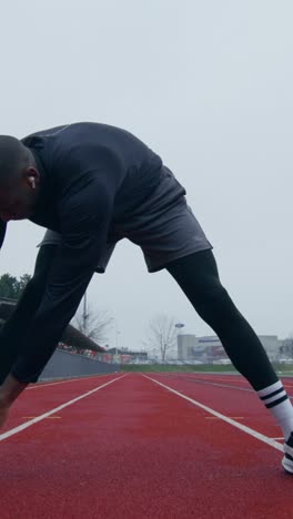 man stretching on a track