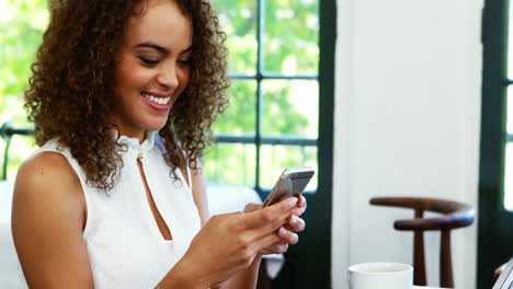 Woman-using-mobile-phone-while-having-coffee-4k