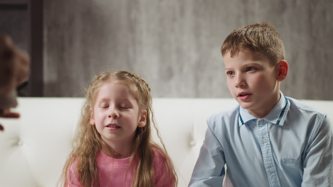 Attentive siblings look at cards shown by English teacher