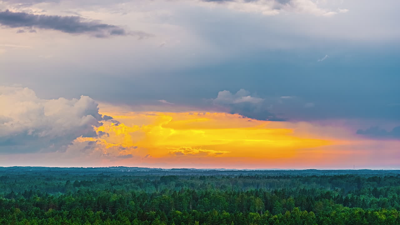 Vibrant sunset clouds over lush forest in a peaceful evening hyperlapse