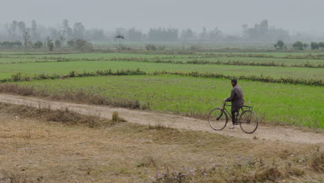 local man riding a bicycle in rural region of eastern nepal