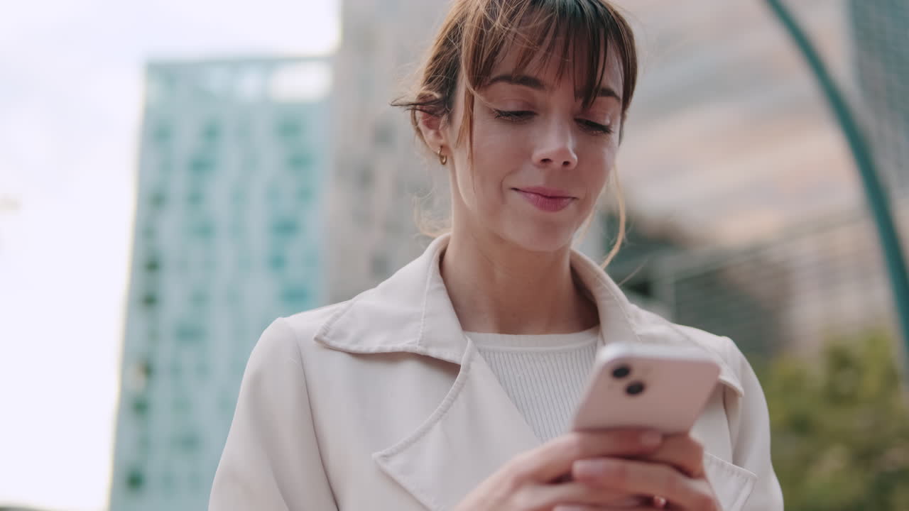 Giovane donna che usa lo smartphone all'aperto in una città moderna