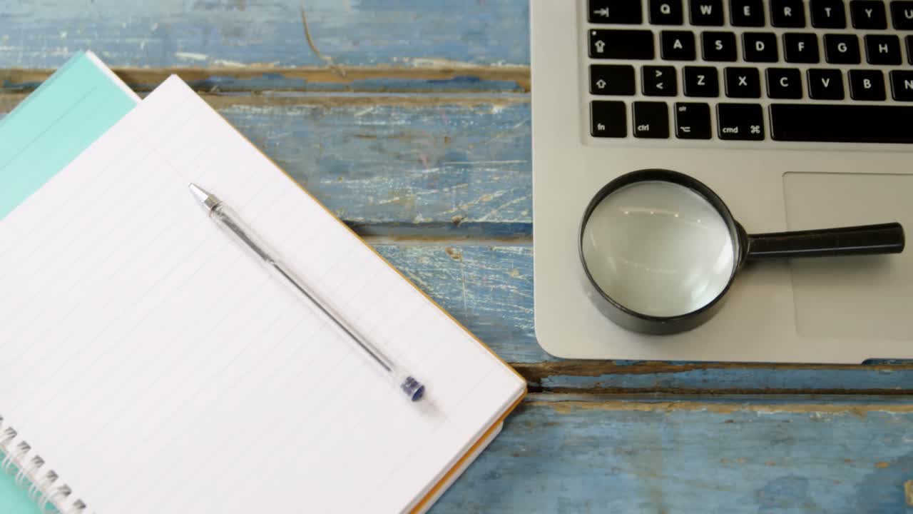 organizador, bolígrafo, lupa y portátil en la mesa 4k