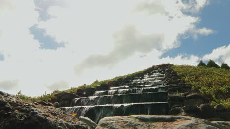 waterfall cascading on staircase steps of a pyramid shaped landscape