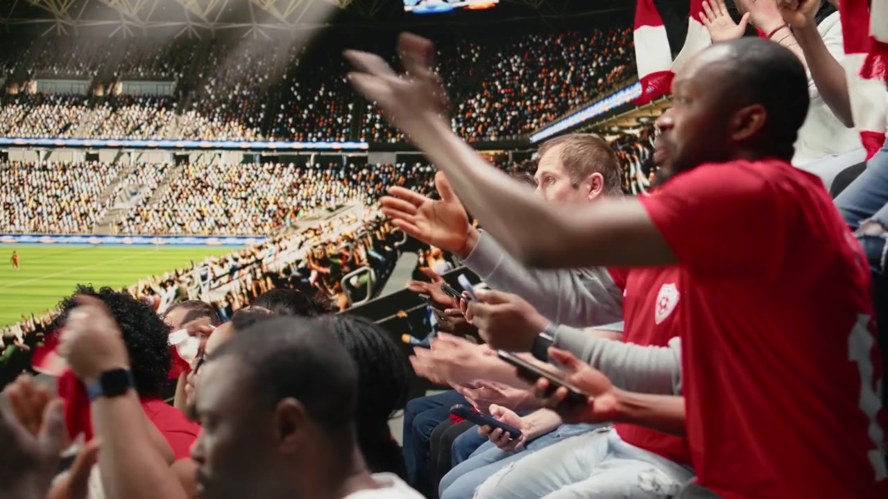 Aficionados afroamericanos siguiendo el marcador en vivo para un boleto de apuesta en una aplicación móvil