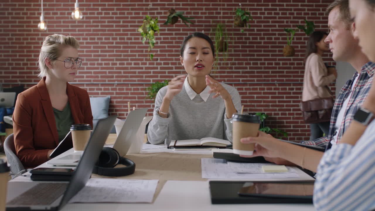 diverse business people engineers developing mobile software application asian team leader woman sharing ideas brainstorming meeting shareholders in office