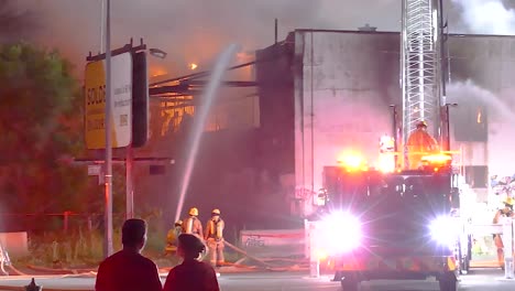 firefighters battle building fire at night